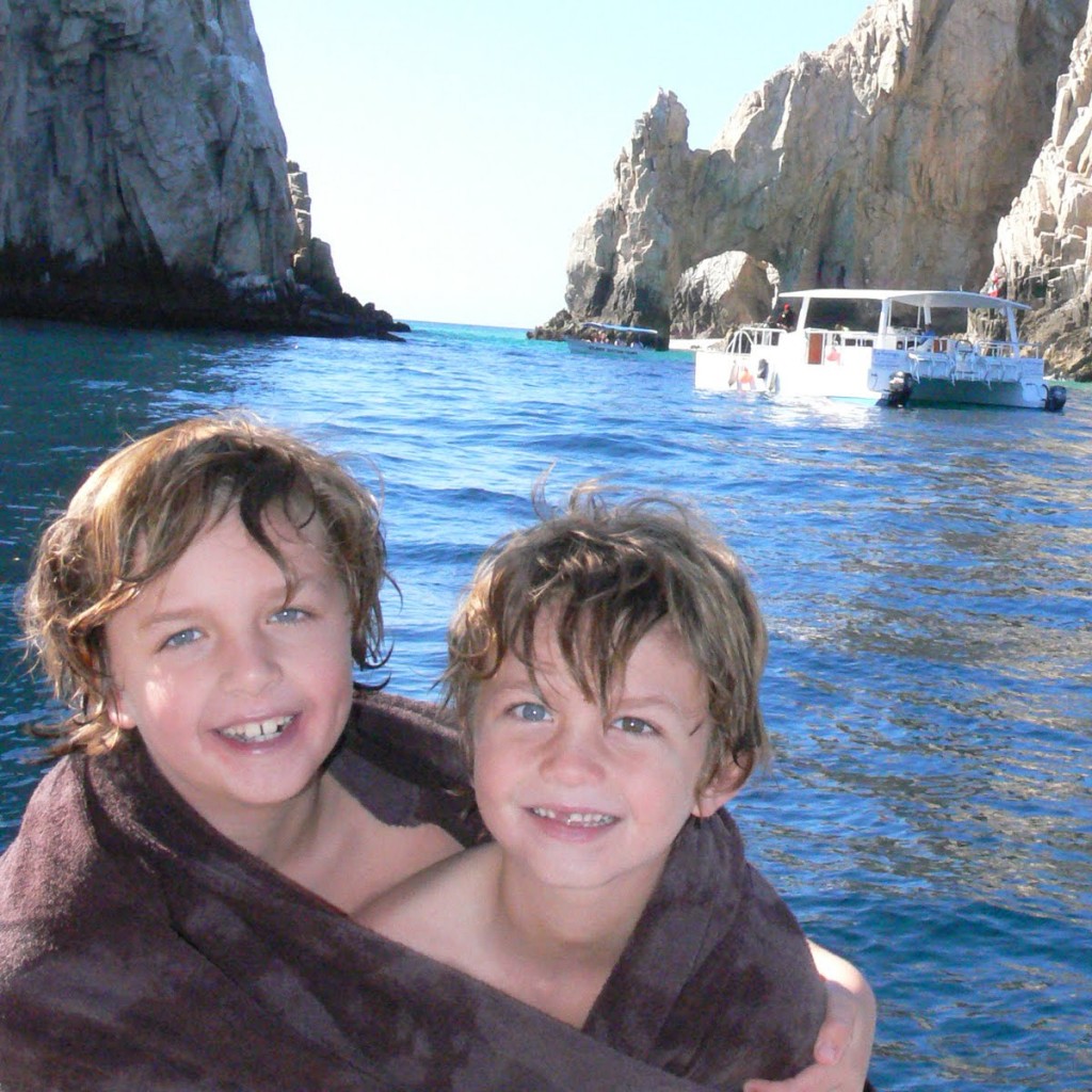 two boys in front of arch in cabo san lucas