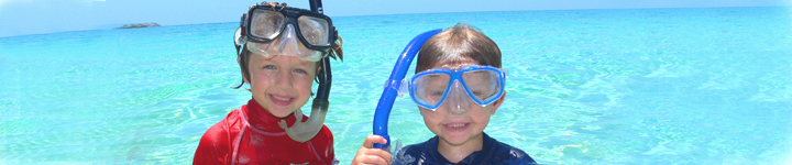 Kids in snorkel gear in turquoise Caribbean Sea