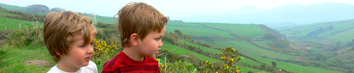 Boys looking over rolling green hills on dingle peninsula in Ireland
