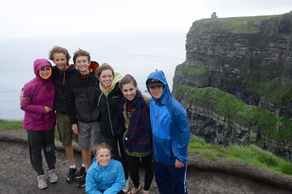 Kids in group hiking along Cliffs of Moher, Ireland