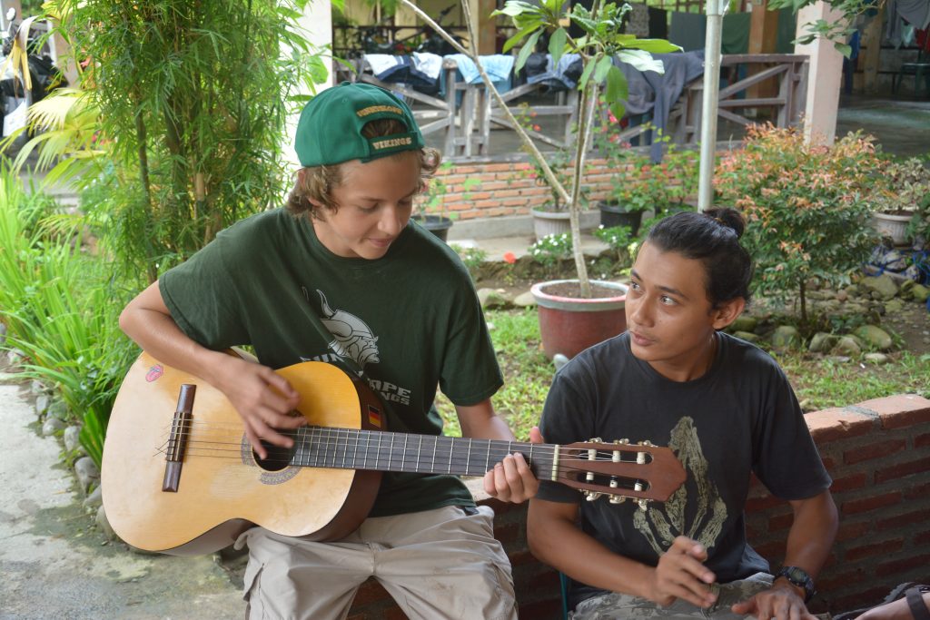 Nathan playing guitar with locals in Sumatra, Indonesia