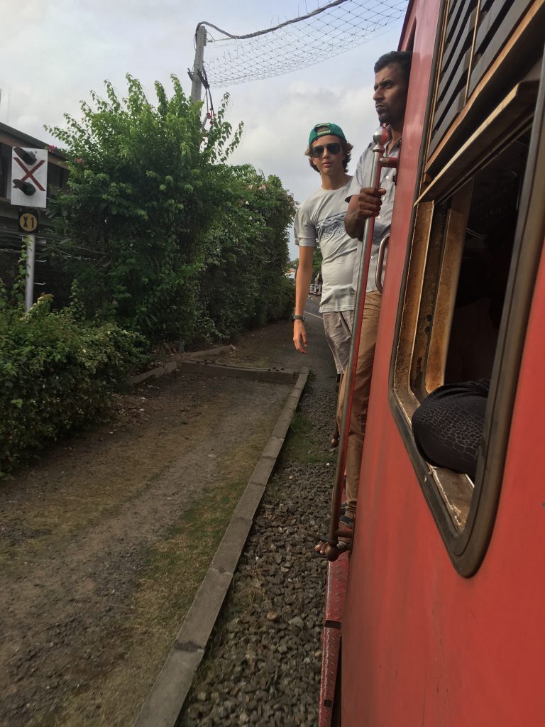 Nathan in open doorway of train from Colombo to Galle on a family trip in Sri Lanka