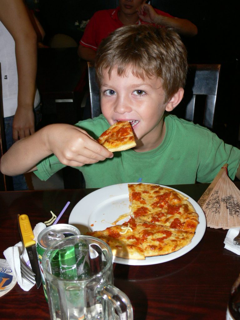 child eating pizza