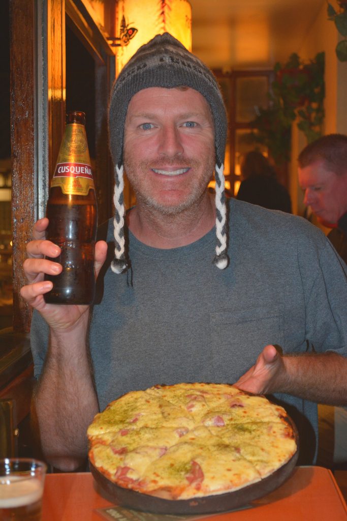 man holding pizza and beer