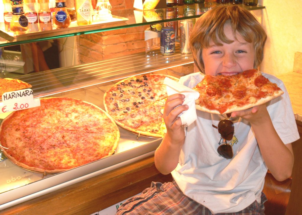 Boy eating giant slice of pizza