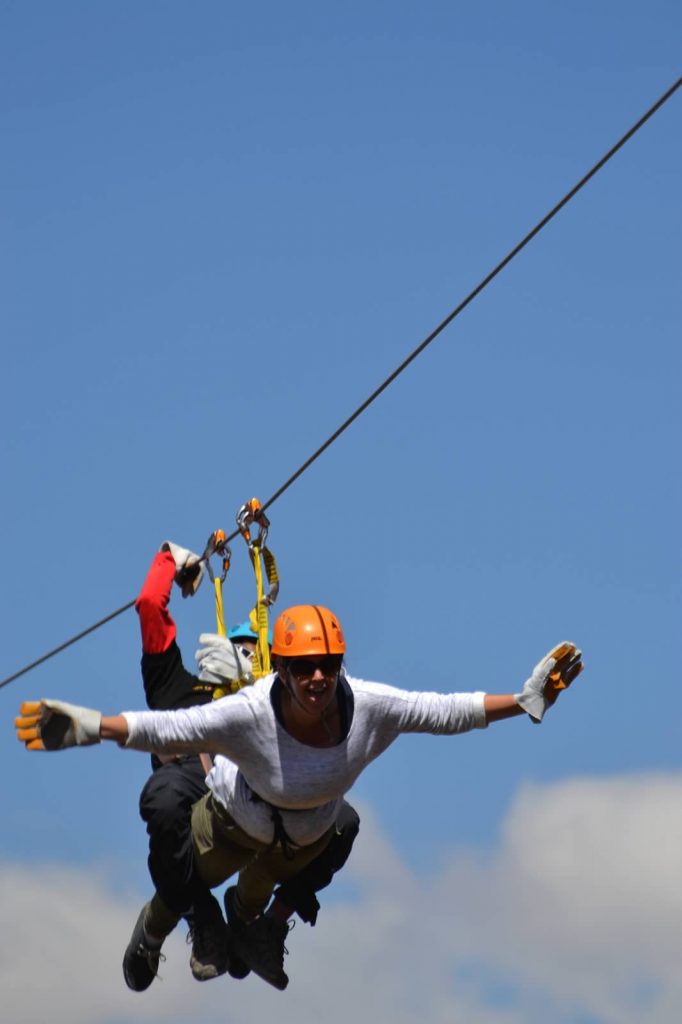 Woman on zipline in Peru in superman pose