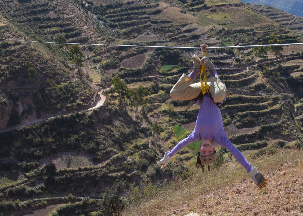 Girl in Spiderman pose on Sacred Valley zip line in Peru