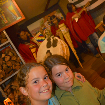 Girls with traditional Peruvian musicians in the background