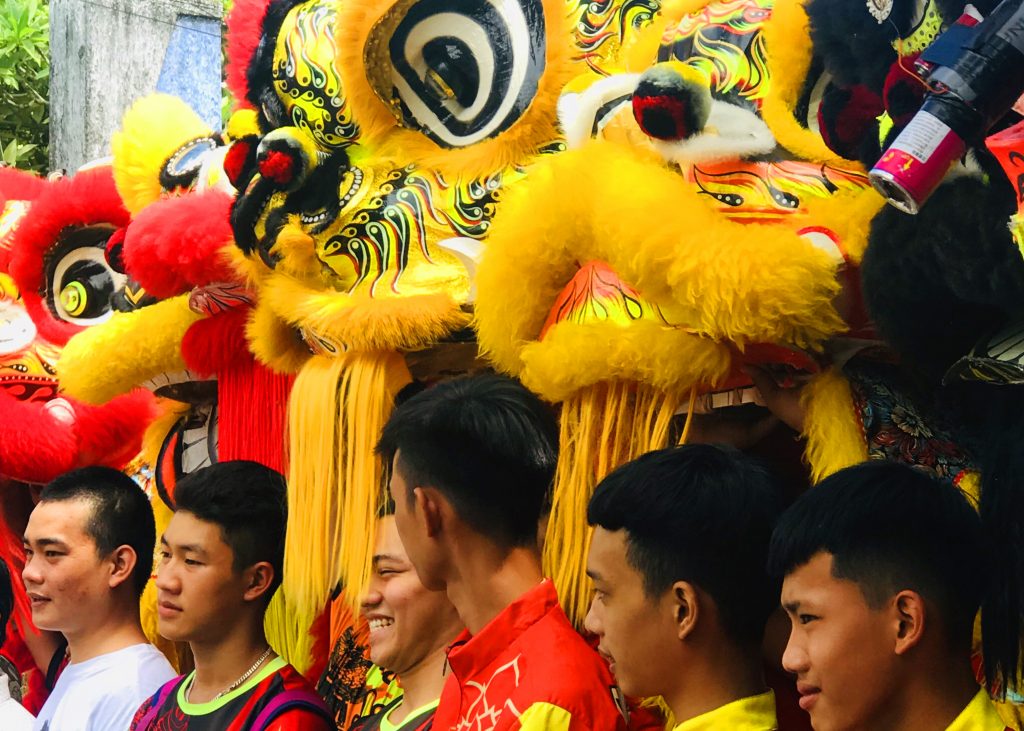 Teenage boys pose with dragon heads in festival in Vietnam